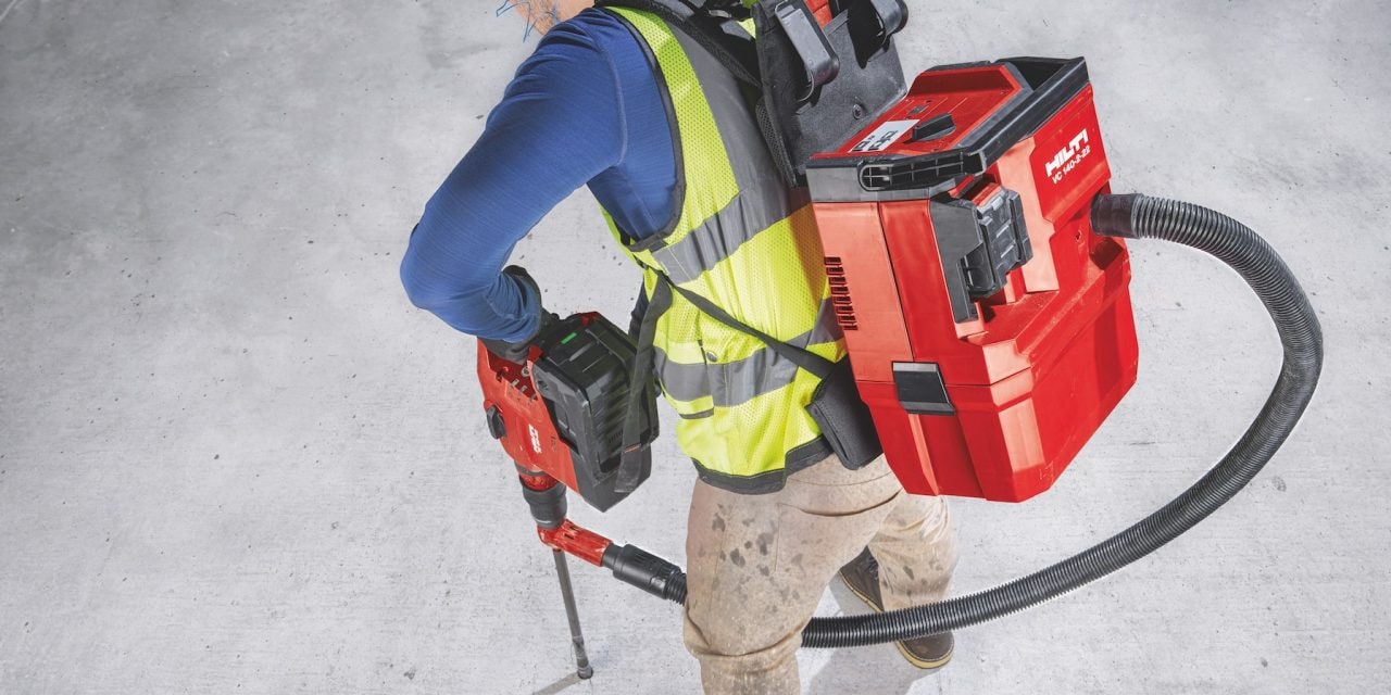 Construction worker using Hilti SafeSet installation method with VC 140-2-22 "vac-pack" vacuum and TE 60-22 cordless rotary hammer